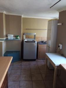 a small kitchen with a refrigerator and a sink at Nandi's Place in Harrismith