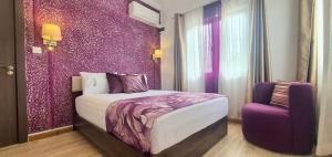 a bedroom with a bed and a purple wall at Mont Oreb Villas Onyx Flic en Flac in Flic-en-Flac