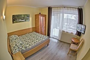 シュクラルスカ・ポレンバにあるWilla Izeryのベッドルーム1室(ベッド1台、大きな窓付)