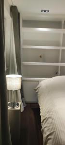 ein Schlafzimmer mit einem weißen Bett und einer Lampe in der Unterkunft Vanbunnen in Knokke-Heist