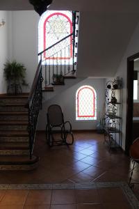 a living room with a staircase and two windows at Casa La Romana in Aracena