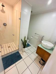 a bathroom with a sink and a shower at The Waves 905 Quayside Point in Durban