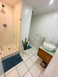 un baño con lavabo y ducha en The Waves 905 Quayside Point, en Durban