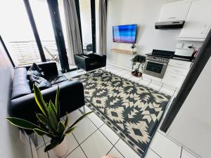 a living room with a couch and a kitchen at The Waves 905 Quayside Point in Durban