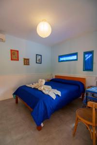 1 dormitorio con 1 cama con edredón azul en El Viejo Algarrobo - Hosteria Serrana en Merlo