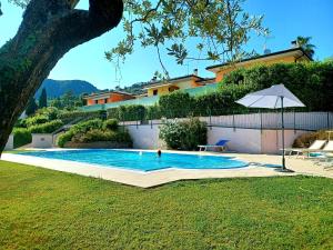 a person in a swimming pool next to a house at REGINA GARDESANA Luxury in Garda