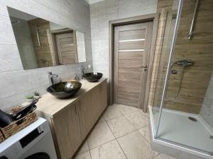 a bathroom with two sinks and a shower at Apartamenty Świerkowa #1 in Ząbkowice Śląskie