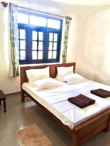 a bedroom with a large bed with a window at Mirihana Residence in Nugegoda