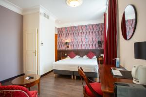 um quarto de hotel com uma cama e uma secretária e um quarto em Best Western Plus Hôtel D'Angleterre em Bourges