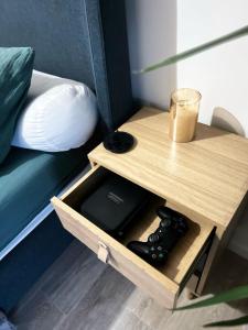 a nightstand with a bed and a table with a remote control at Duplex de la Gare, Grande Terrasse, Jacuzzi in Corbeil-Essonnes