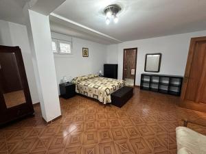Schlafzimmer mit einem Bett und Holzboden in der Unterkunft Casa Kiros in Cangas