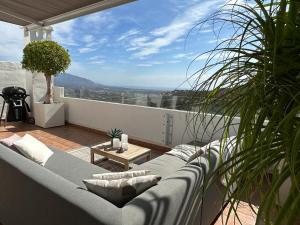 a living room with a couch on a balcony at Penthouse mit privatem Jacuzzi in Marbella - La Mairena in Ojén