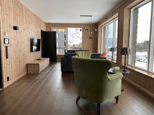 a living room with a couch and a table and chairs at Hemsedal - Fyri Resort - Leiligheter in Hemsedal