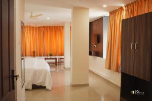 a bedroom with a bed and an orange curtain at GLANCY'S GUEST HOUSE in Haripād