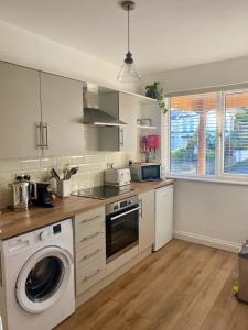 cocina con lavadora y lavavajillas en Luxury coastal retreat, en Teignmouth
