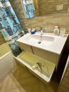 a bathroom with a white sink and a mirror at Casa del sasso in Bergeggi