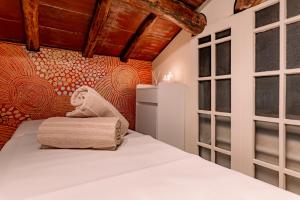 a bedroom with a bed with a blanket and windows at Villa Romantica Wellness & SPA in Lucca