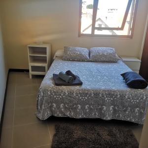 um quarto com uma cama com lençóis azuis e uma janela em Céntrico apartamento en Corrubedo em Corrubedo