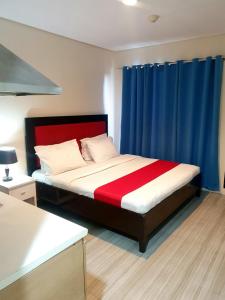 a bedroom with a bed with a red and blue curtain at Sab R. Bel air soho in Manila
