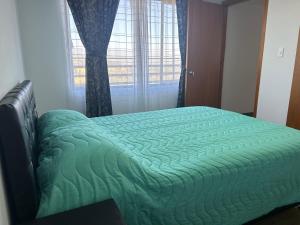 Cama verde en habitación con ventana en Chalet Supérior con Jacuzzi interior ! 30 minutos gratis, en Sogamoso