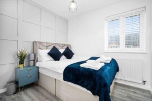 a white bedroom with a large bed with blue blanket at Stunning Modern Home In Birmingham in Birmingham