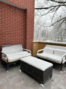 duas camas com neve sobre elas sentadas ao lado de uma parede de tijolos em Wald Hotel Lagodekhi Rooms em Lagodekhi