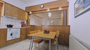 a kitchen with a table and chairs and a clock at STAY Aurum Apartment in Nicosia