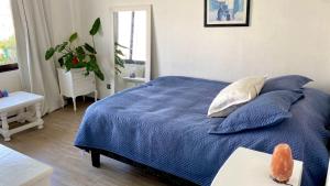 Schlafzimmer mit einem Bett mit blauer Bettwäsche und Kissen in der Unterkunft Hermoso bungalow con vista al mar in Concón