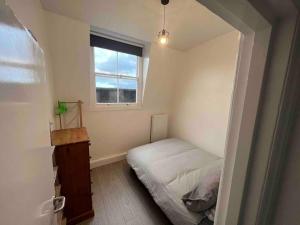 ein kleines Schlafzimmer mit einem Bett und einem Fenster in der Unterkunft 2 Bed Apartment in Central London on 3rd floor - Newly refurbished - No lift in London