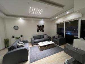 a living room with two couches and a tv at Prime apartment with amazing view in Amman in Amman
