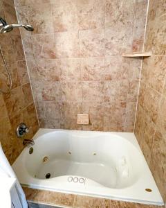 a bath tub in a bathroom with a shower at Quiet home 15min from FQ, 10min from Trendy Bywater Neighborhood in Arabi +6 photos