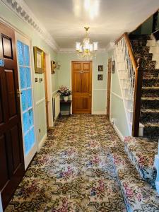 a hallway with a staircase and a carpeted floor at Unwind in comfort at cosy Caradus your 8 bed Home Sweet Home! in Birmingham