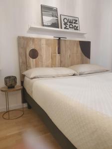 - une chambre avec un lit et une tête de lit en bois dans l'établissement Appartamento con terrazzo privato Milano San Raffaele Linea verde, à Vimodrone