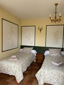 two beds in a room with pictures on the wall at La Valinière in Seur