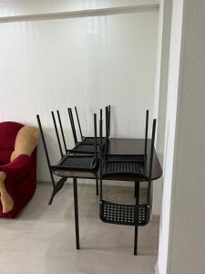 アルマトイにあるNureke Apartmentsのソファの隣に椅子2脚とテーブル1台