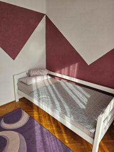Cama en habitación con pared púrpura en Stevin ranc, en Bosanska Dubica