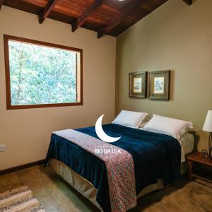 1 dormitorio con cama y ventana en Espaço Rio da Lua - Casas - Cipó, Mata, Madeira e Tororão - São Jorge GO, en São Jorge