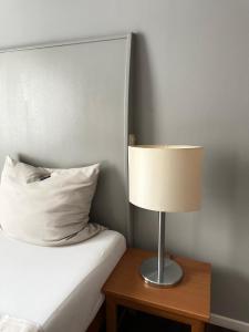 um candeeiro sentado numa mesa ao lado de uma cama em Hotel Ambiente em Dortmund