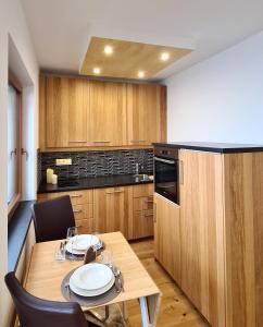 cocina con mesa de madera y comedor en Superior Apartment Eva, en Heiligenblut