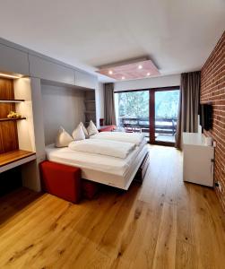 1 dormitorio con 1 cama grande y pared de ladrillo en Superior Apartment Eva, en Heiligenblut