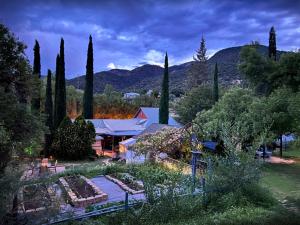 a house with a garden with trees and mountains at Mile High Ranch in Bisbee