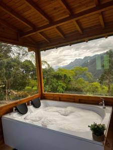 a bath tub in a room with a large window at Glamping Shalom in Choachí