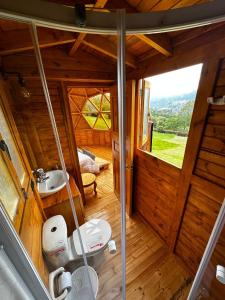 a small bathroom with a toilet and a sink at Glamping Shalom in Choachí +42 photos