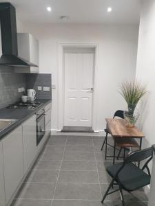een keuken met een tafel en stoelen en een deur bij SWEET DREAMS 2 in Luton
