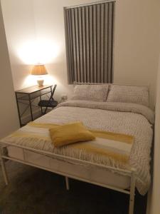 Una cama con una almohada amarilla en un dormitorio en SWEET DREAMS 2 en Luton
