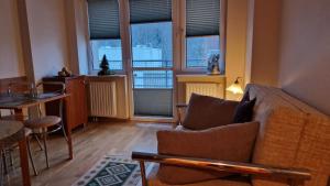a living room with a couch and some windows at Apartament Gwiazda 306 in Krynica Zdrój