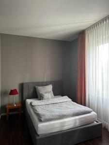 a bed in a bedroom with a window and a table at Hotel Ambiente in Dortmund
