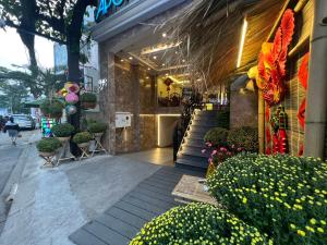 Apollo Airport Hotel في مدينة هوشي منه: واجهة محل بالنباتات والورود على شارع