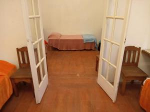 Habitación con puerta, 2 sillas y 1 cama en Pousada Inaya, en Petrópolis