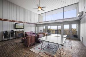 - un salon avec une table de ping-pong et des chaises dans l'établissement Cute Cedar Lodge Studio with Balcony & Lake Views!, à Laconia